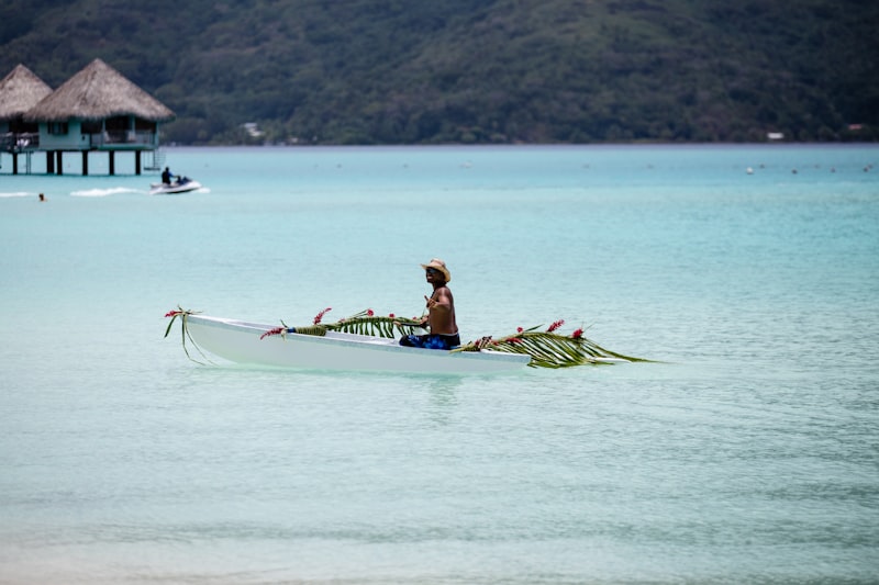 person riding on boat near hut